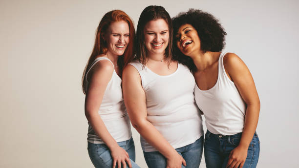 Diverse group of women laughing together Diverse group of women laughing together on white background. Females in casuals looking happy together. slim photos stock pictures, royalty-free photos & images