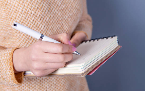 istock notebook pen and  writing girl 1132444850