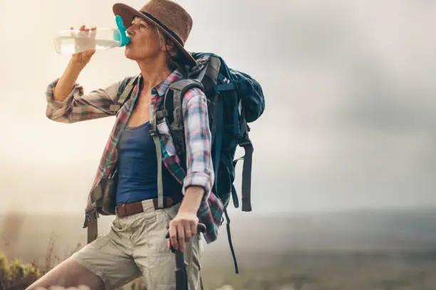 Photo of Portrait of a female hiker drinking water
