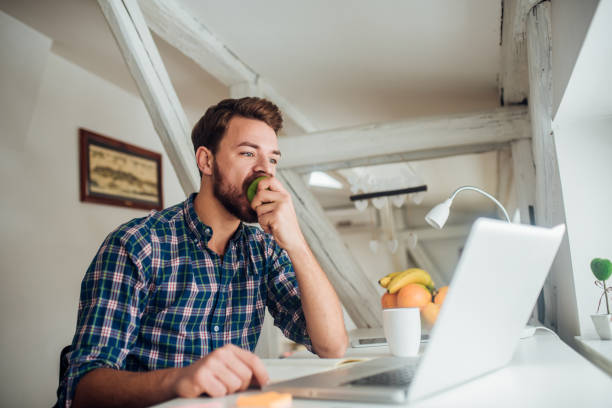 istock Man taking a bite of an apple 1132448396