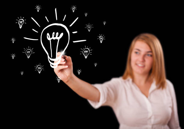woman drawing light bulb on whiteboard - profile photo flash imagens e fotografias de stock
