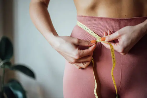 Photo of Fit woman measuring her waist