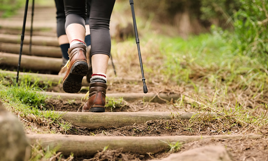 Rear view shot of an unrecognizable woman hiking up the steps on mountain trail