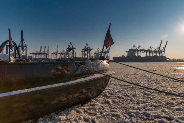 Jetty in Hamburg in winter weather with harbor cranes