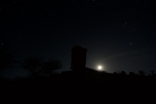 Vingerklip rock in Namibia captured in front of the rising moon.