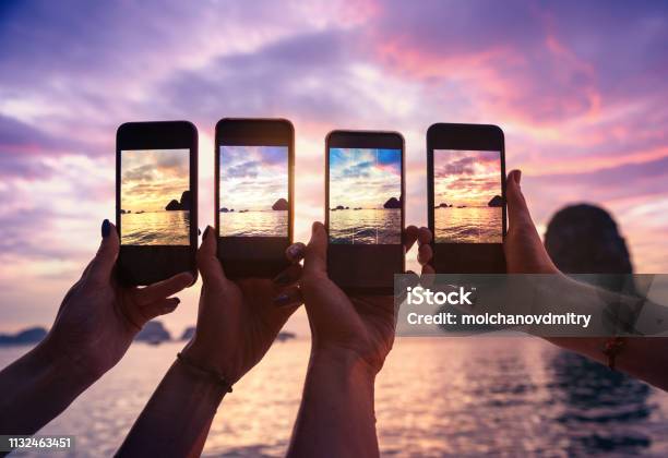 Cuatro Manos Con Los Teléfonos Móviles Que Toman La Foto Foto de stock y más banco de imágenes de Teléfono inteligente