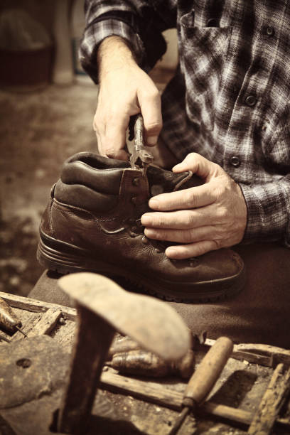 istock Midsection Of Male Shoemaker Making Shoe In Workshop 1132464381