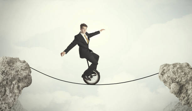 istock Brave business man riding an mono cycle between cliffs 1132466879