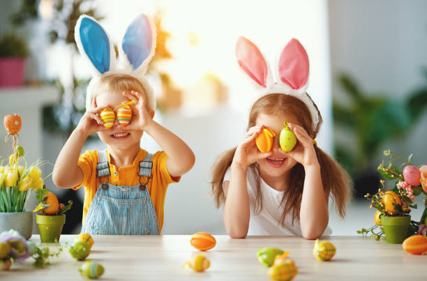 wesołych świąt! śmieszne śmieszne dzieci z uszami zając przygotowuje się do wakacji - easter baby rabbit eggs zdjęcia i obrazy z banku zdjęć