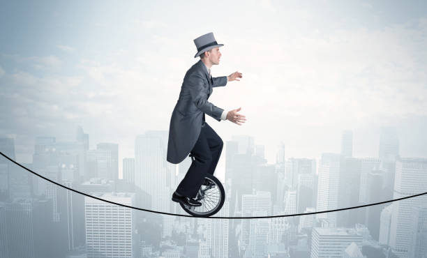 istock Brave guy riding a monocycle on a rope above cityscape 1132467004