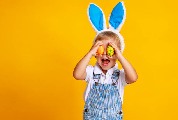 istock funny happy child boy with easter eggs and bunny ears on yellow 1132467819