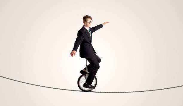 istock Extreme business man riding unicycle on a rope 1132467944