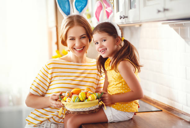 ハッピーイースター!家族の母と子の娘と耳ウサギの準備のための休日 - easter egg easter yellow paint ストックフォトと画像