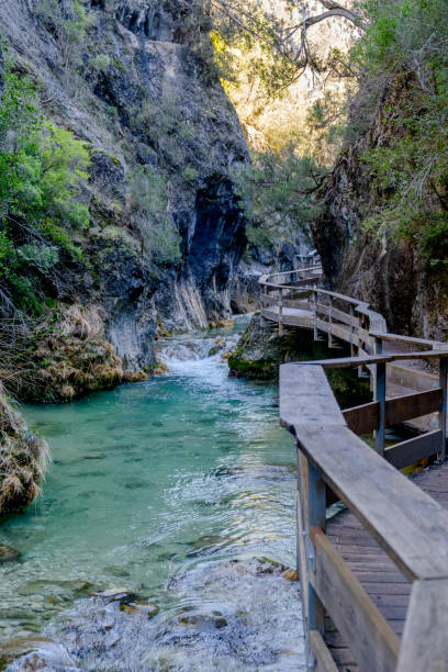istock Landscape with a river running through a narrow valley between mountains with a wooden footbridge 1132468413