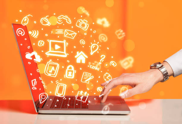istock Hand writing on notebook computer with media icons and symbols 1132469225