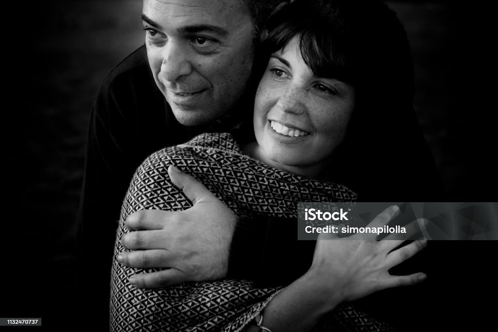 belle beau moyen âge 40 ans vieux couple homme et femme caucasien étreint et rester ensemble sur la plage s'asseyant dans le sable et appréciant un Golde étonnant coucher de soleil pour l'activité de loisirs de Nice en plein air dans la nature - Photo de 35-39 ans libre de droits