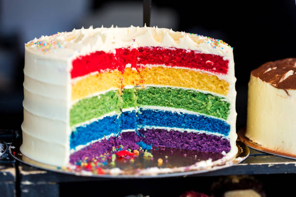 kreuzschnitt der fresh regenbow layer cake auf dem lebensmittelmarkt schließen - fat layer stock-fotos und bilder