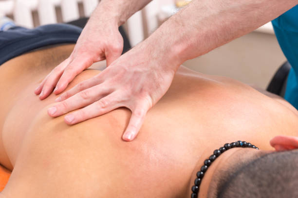 istock Male Massage Therapist Giving Back Massage to Man 1132473040