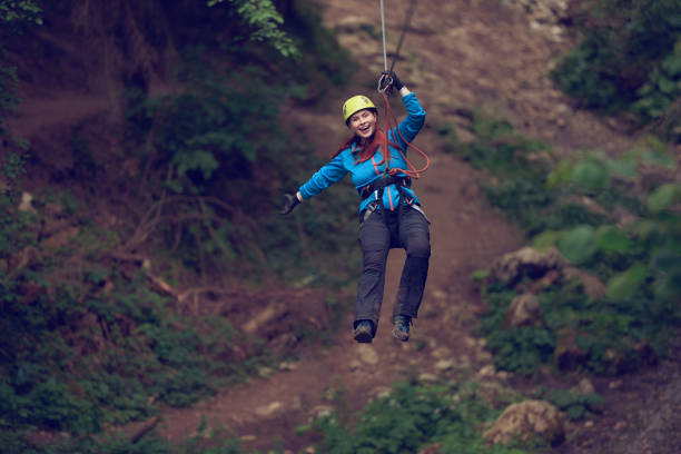 spaßzeit beim reißverschluss - ziplining zip line outdoors zip lining stock-fotos und bilder