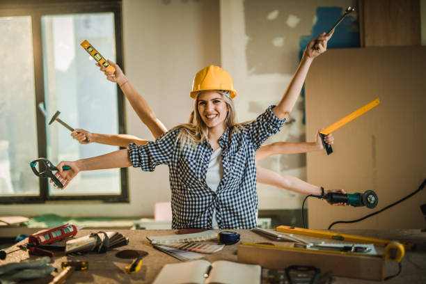 istock Happy multi-tasking construction worker in renovating apartment looking at camera. 1132477283