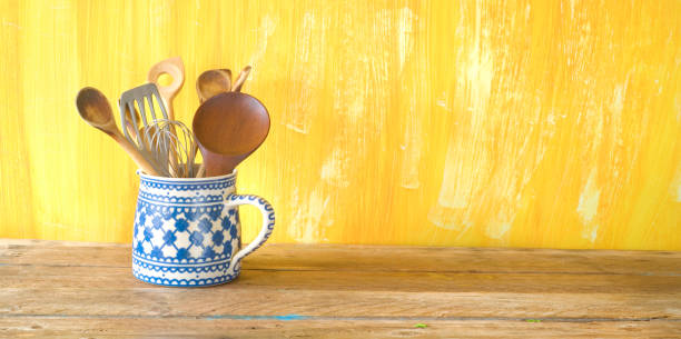 istock kitchen utensils in an old jug, good copy space on painted yellow wall, panorama ,large copy space 1132478909