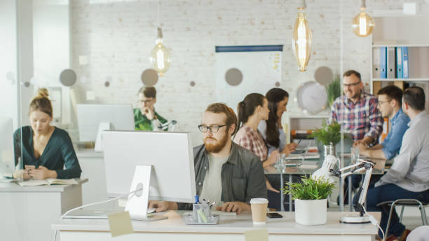 istock Shot of a Busy Creative Office. Office People Working at Their Personal Computers, Talking on the Phone, Moving Around. At the Conference Table Business Discussion is Taking Place. 1132478949