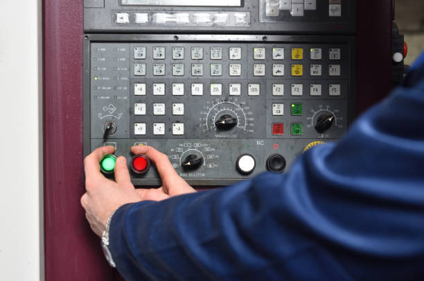 istock Worker in blue workwear holds hands on the control panel of the CNC machine. Close-up 1132482587