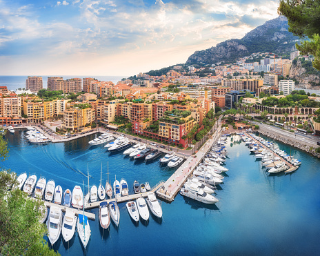 April 30, 2023: This photo shows the glamorous and luxurious principality of Monaco, nestled on the stunning French Riviera. The image captures a panoramic view of the cityscape, featuring the towering hillside, opulent architecture, and the Mediterranean Sea. The photo is also adorned with the yachts moored in the harbor.
