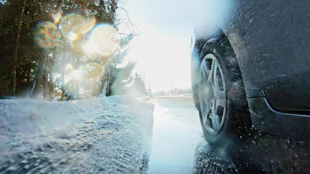 Car Driving Winter tires on snow road close up stock photo