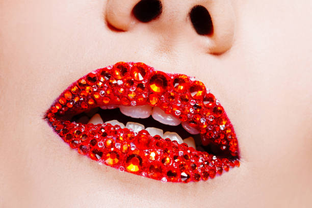 istock Red lips covered with rhinestones. Beautiful woman with red lipstick on her lips 1132485604