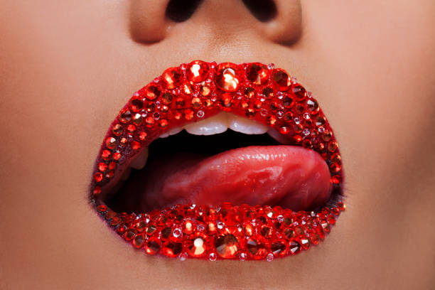 istock Red lips covered with rhinestones. Beautiful woman with red lipstick on her lips 1132485609