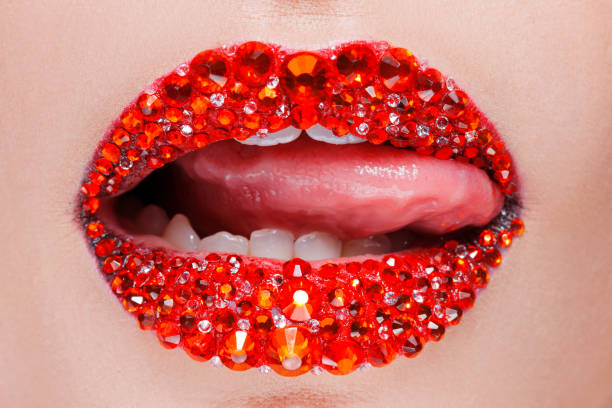 istock Red lips covered with rhinestones. Beautiful woman with red lipstick on her lips 1132485621