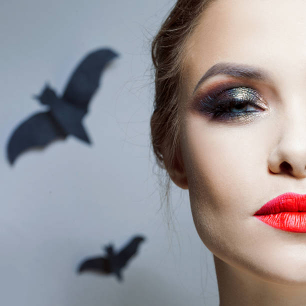 Halloween makeup, bright and stylish girl with red lips and Smokey eyes makeup. stock photo