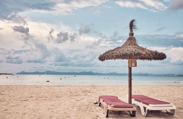 istock Umbrella and pair of sunbeds on a beach. 1132487146