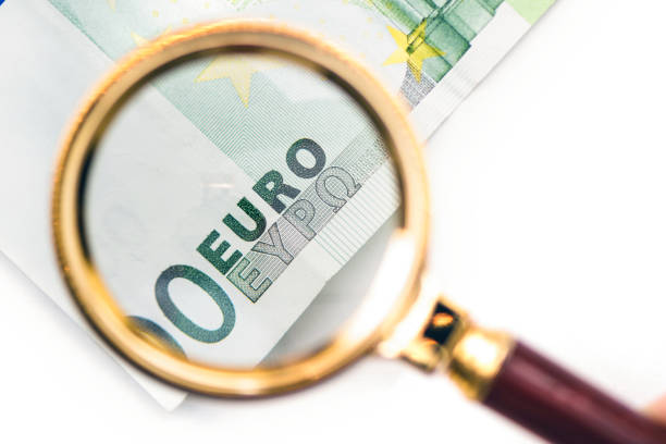 istock Hundred euro bill under a magnifying glass in the human hand. Concept 1132489448