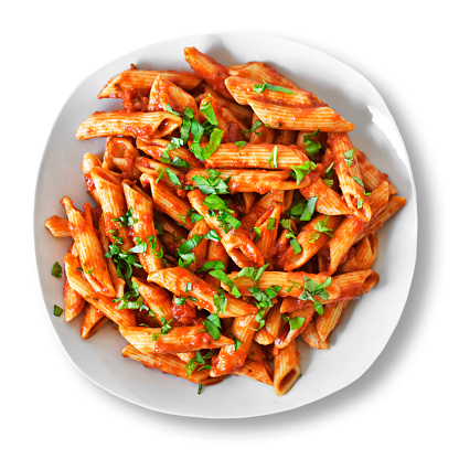Delicious pasta dish with fresh basil on white background. Top view scene, healthy eating or healthy lifestyle. Penne napoli or pasta arrabiata, isolated.