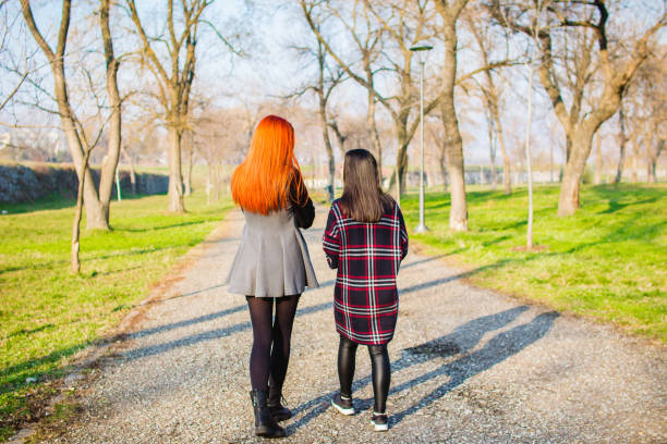 istock Two young women walking in park 1132492790