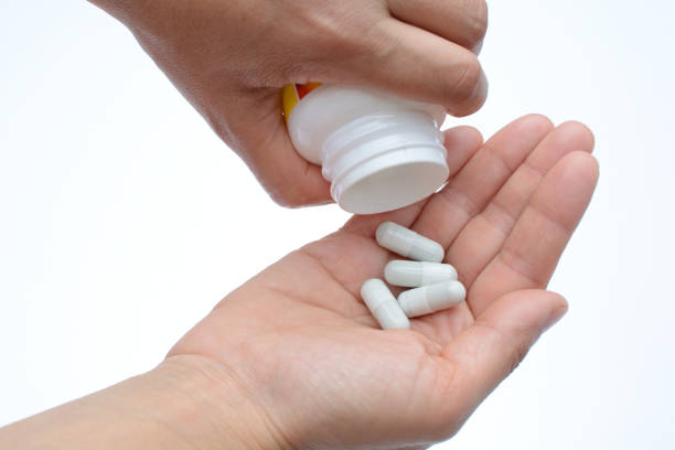 istock Pouring capsules from a pill bottle into hand 1132492925