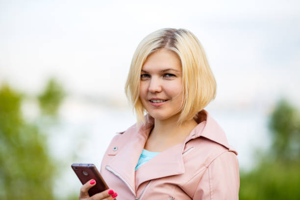 istock Woman in the park writes sms 1132493857