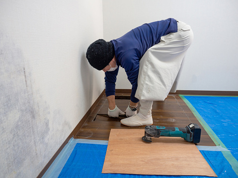 Japanese construction worker tearing off a floor.