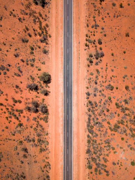вид с высоты птичьего полета на живописное шоссе в глубинке - australian outback стоковые фото и изображения