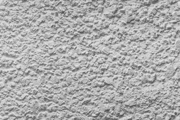 istock Black and white whitewashed concrete wall interspersed with stones 1132496429