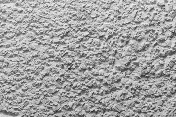 istock Black and white whitewashed concrete wall interspersed with stones 1132496469