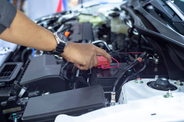 hands of car mechanic working in battery check. - car battery imagens e fotografias de stock