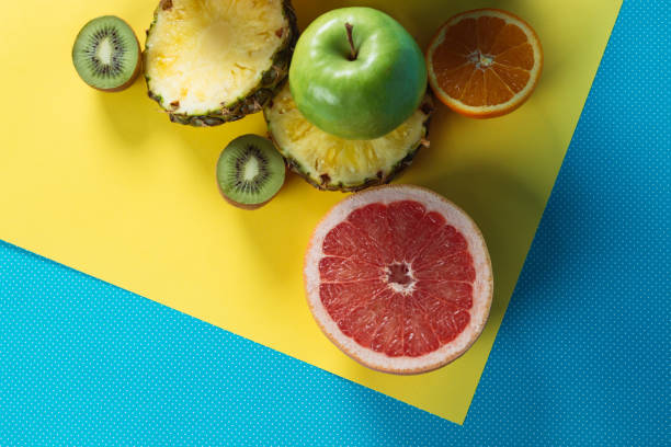 istock Different kinds of fruit on blue and yellow  background. 1132497783
