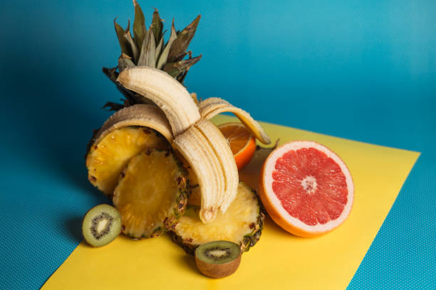 istock Different kinds of fruit on blue and yellow  background. 1132497800