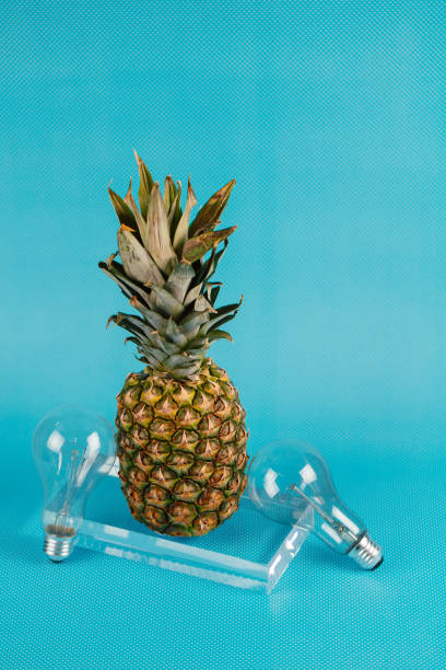 istock Different kinds of fruit and electric bulbs on blue background. 1132498679