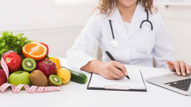 istock Nutritionist doctor writing diet plan on table 1132501479