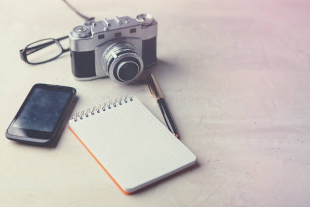 istock Retro photo camera with white note book on a stylish wooden background 1132501759