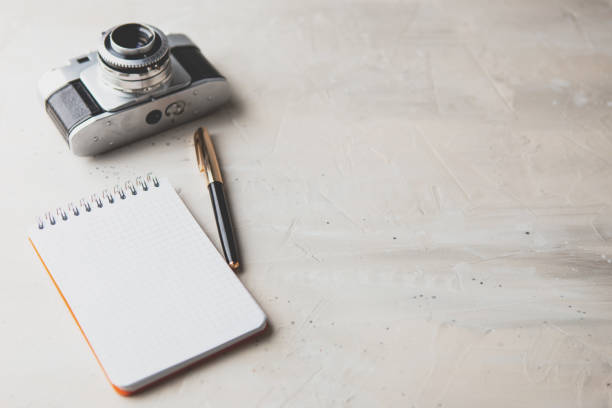 istock Retro photo camera with white note book on a stylish wooden background 1132501761